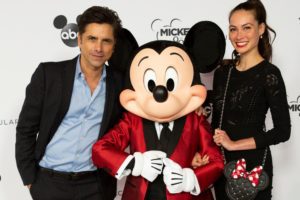 John Stamos and Caitlin McHugh pose together on the red carpet at the 90th Spectacular